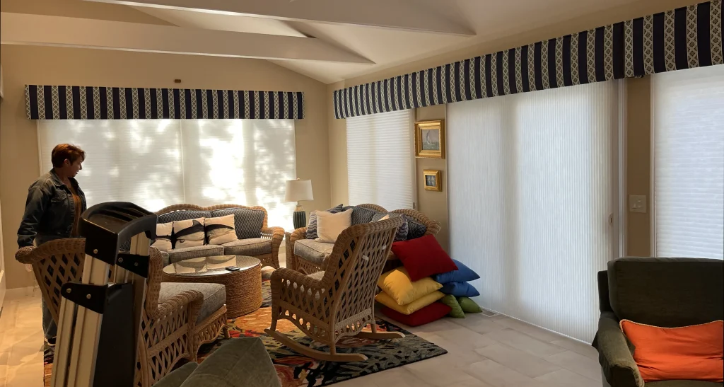 Custom tailored navy and white striped fabric cornices paired with premium white cellular shades in a coastal Cape Cod living room.