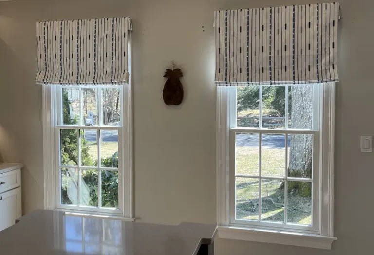 Custom installed fabric Roman shades in a sunlit Outer Cape living room